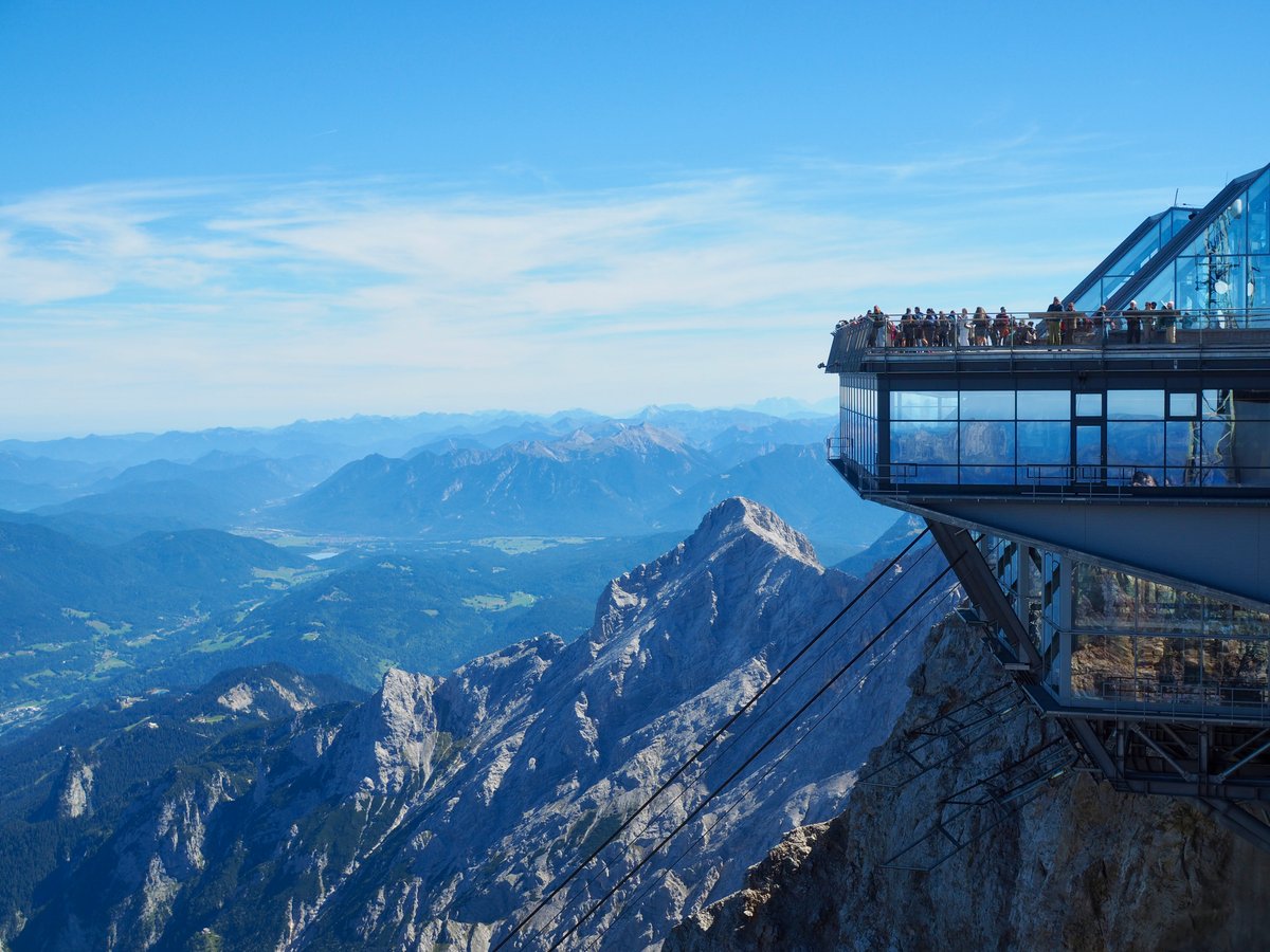 A view from the Austrian side of the Zugspitze summit looking at the mountains and visitors platform on the German side.